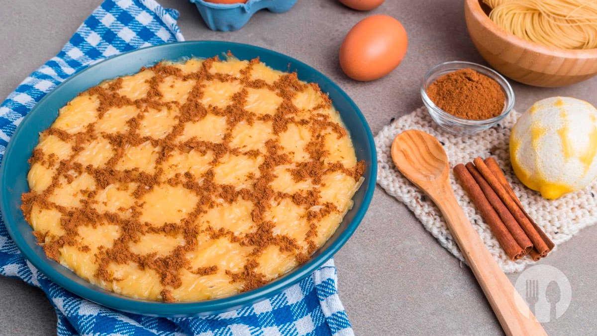 Aletria tradicional portuguesa cremosa numa travessa, decorada com canela em pó.